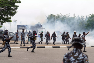 Nigeria protesters turn sideways as police fire shots and tear gas