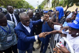 Romuald Wadagni, Benin's finance minister and the ruling party candidate for the presidential election, shakes hands with supporters after presenting his platform in Cotonou, Benin March 21, 2026.